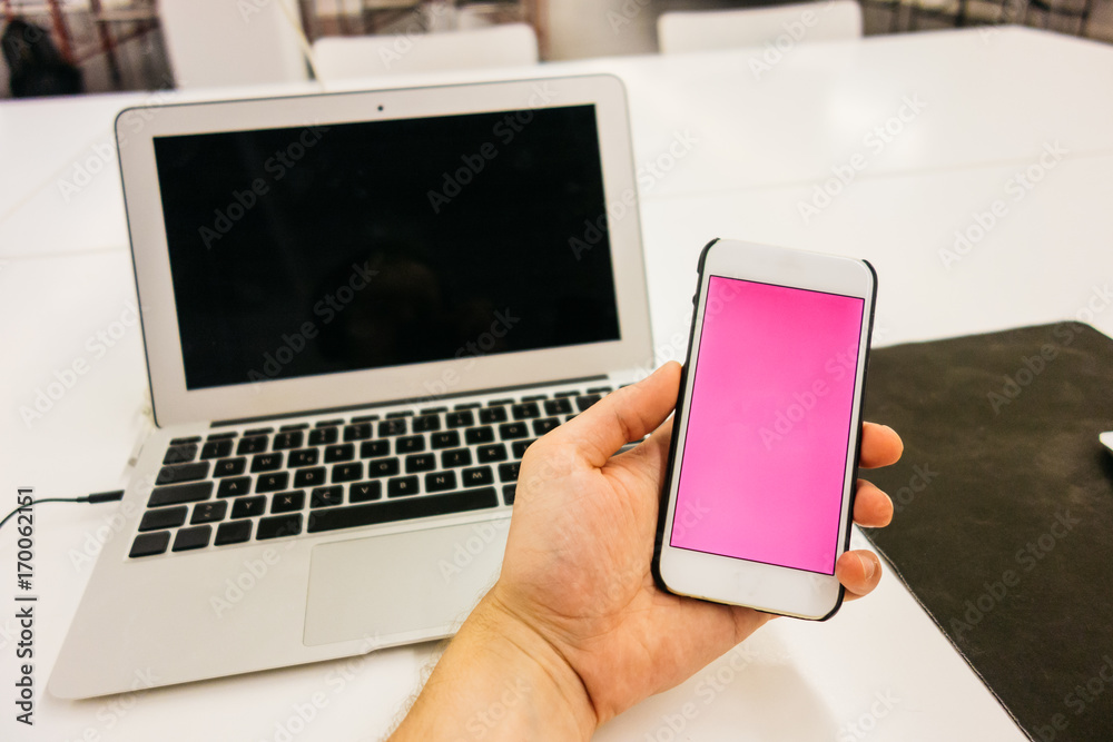 man is holding an smartphone with notebook in the background man is holding an smartphone with notebook in the background