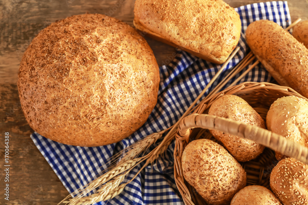 Beautiful composition with wicker basket and delicious bread on wooden table