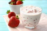 Delicious strawberry yogurt on table