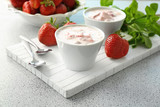 Bowls with delicious strawberry yogurt on table
