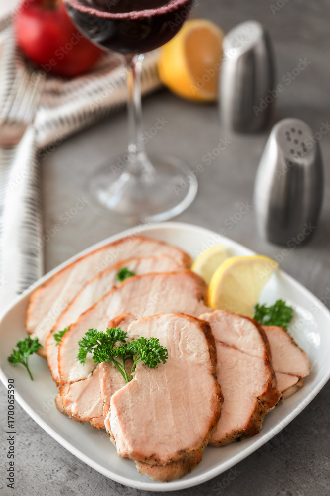 Plate with delicious sliced turkey fillet on table