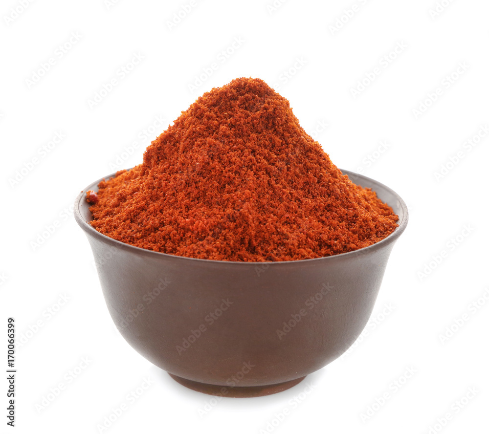 Heap of chili powder in brown pottery bowl isolated on white Heap of chili powder in brown pottery bowl isolated on white