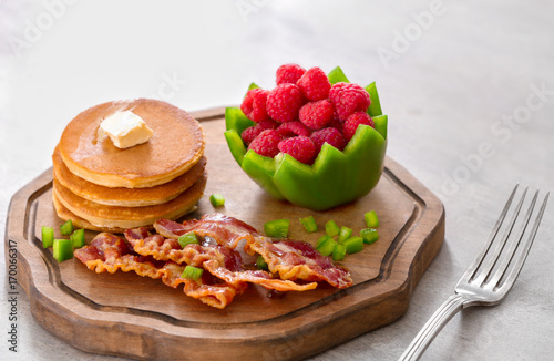Tasty breakfast with pancakes  bacon and raspberry on wooden board