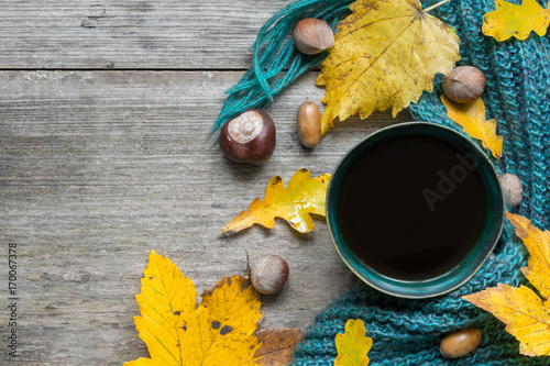 Autumn background with dry leaves, scarf and hot cup of coffee on wooden table © samael334