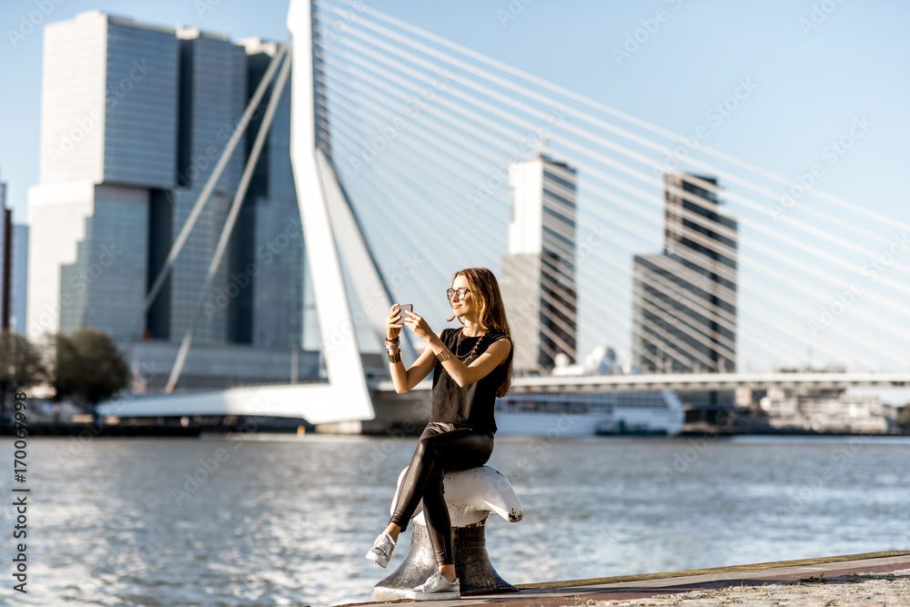 Woman enjoying beautiful cityscape view on the modern riverside during the morning in Rotterdam city