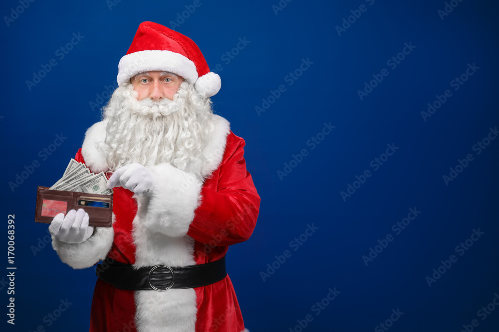 Santa Claus holding purse with money on color background Santa Claus holding purse with money on color background