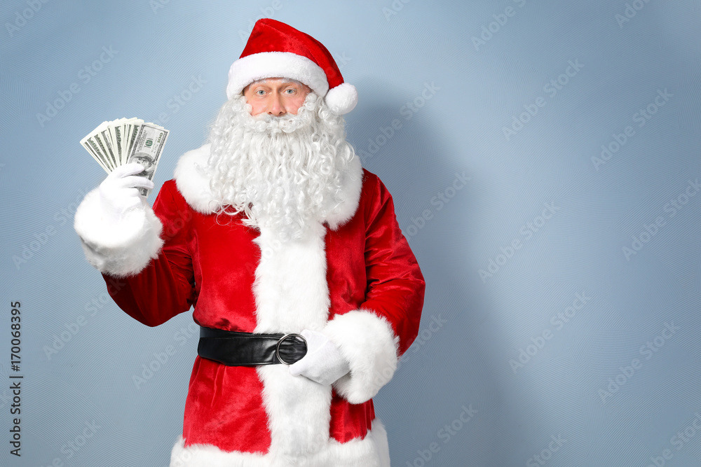 Santa Claus holding money on light background Santa Claus holding money on light background