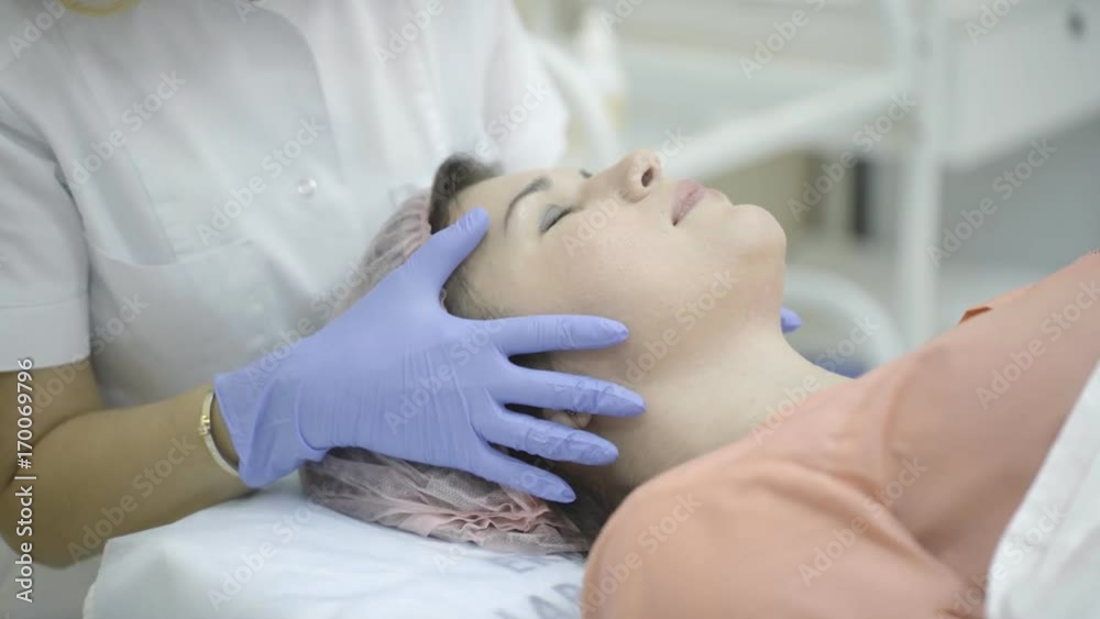 Beautician examining face adult woman lying on the couch Beautician examining face adult woman lying on the couch