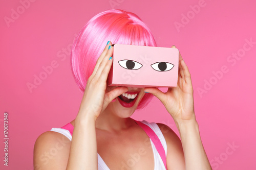 femme sexy avec perruque rose regardant dans  une boîte de réalité virtuelle