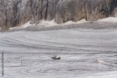 Snow groomer snowcat stands on Dachstein glacier near cable car photo