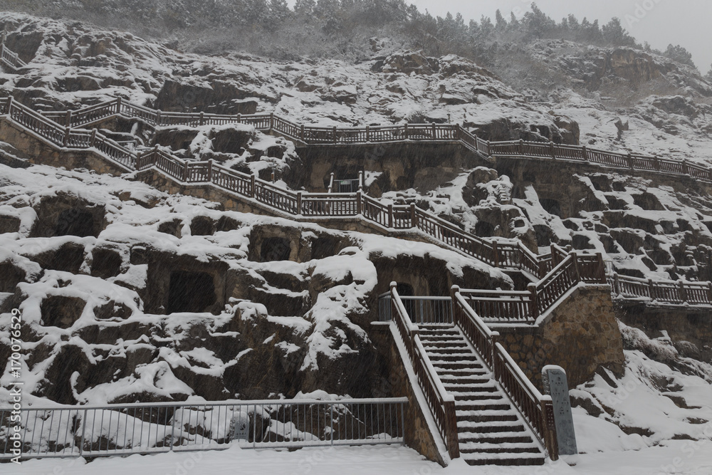 Longmen Grottoes (Longmen Caves) at Luoyang, China under heavy snow. The Longmen Grottoes are one of the finest examples of Chinese Buddhist art.