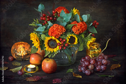 Thanksgiving decor with candle and sunflowers on a dark wooden background. Autumn harvest. 