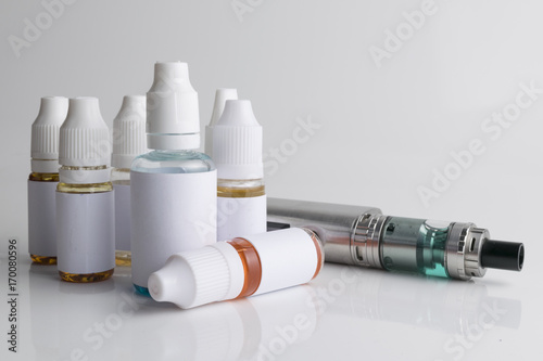 Isolated e liquid bottles and electronic cigarette, e cig for vape devices over a white background