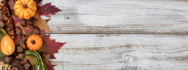 Autumn foliage with other fall decorations on white rustic wooden boards