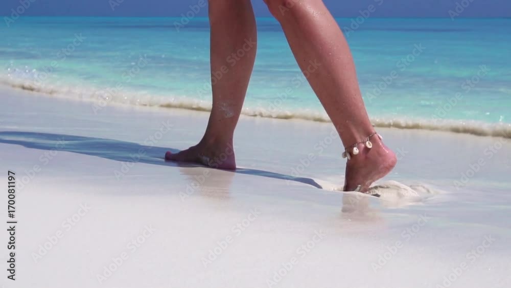 Beautiful woman legs, walking along the beach. Leaving footprints on sand Beautiful woman legs, walking along the beach. Leaving footprints on sand