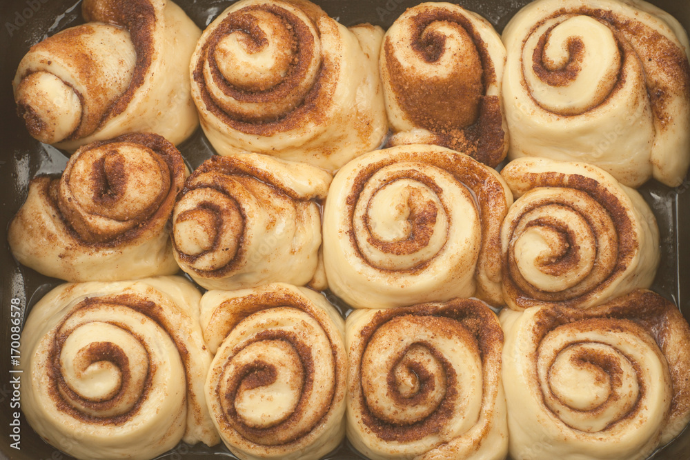 Cinnamon rolls or cinnabon handmade raw dough preparation sweet traditional dessert buns pastry food baked homemade swirl Danish mini snack