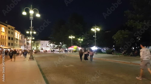 Summer night with people walking in the Belluno main square, Veneto, Italy