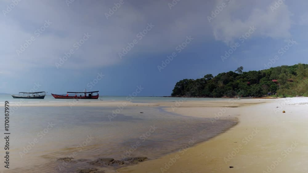 White sand beach under blue sky tropical landscape with fishing boats in shallow water White sand beach under blue sky tropical landscape with fishing boats in shallow water