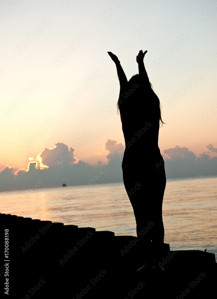 Silhouette human open empty hands with palms up over sun on sunrise background