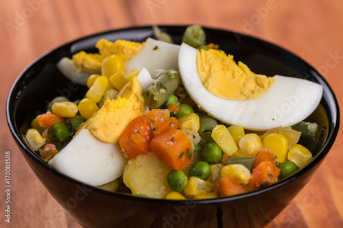 Closeup macro vegetable salad with corn eggs potatoes carrot