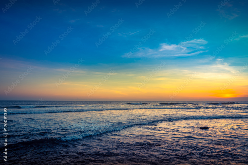 Blue Waves near sea Resort. Isolated Sea Sunset. Surfing Beach with Surfers on the Horizon. Landscape. Sunset Background Ocean. Tropical Sunlight and Summer Sunset View. Colorful Background Sunset. 
