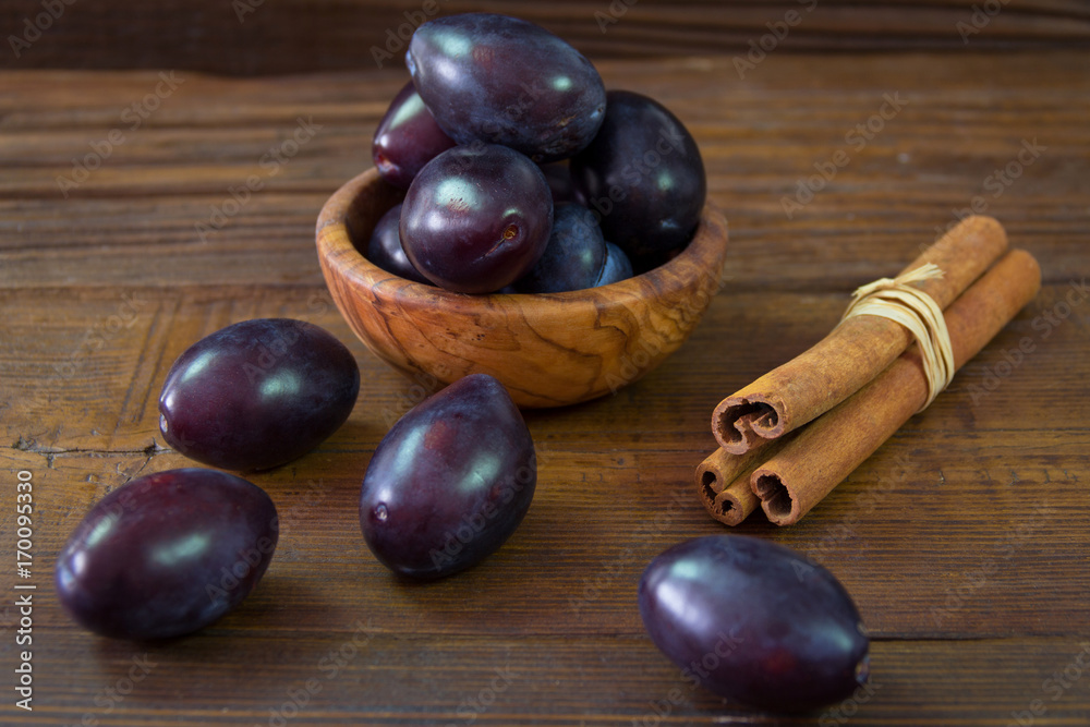 Plums in the bowl and plums sprinkled on the table Plums in the bowl and plums sprinkled on the table