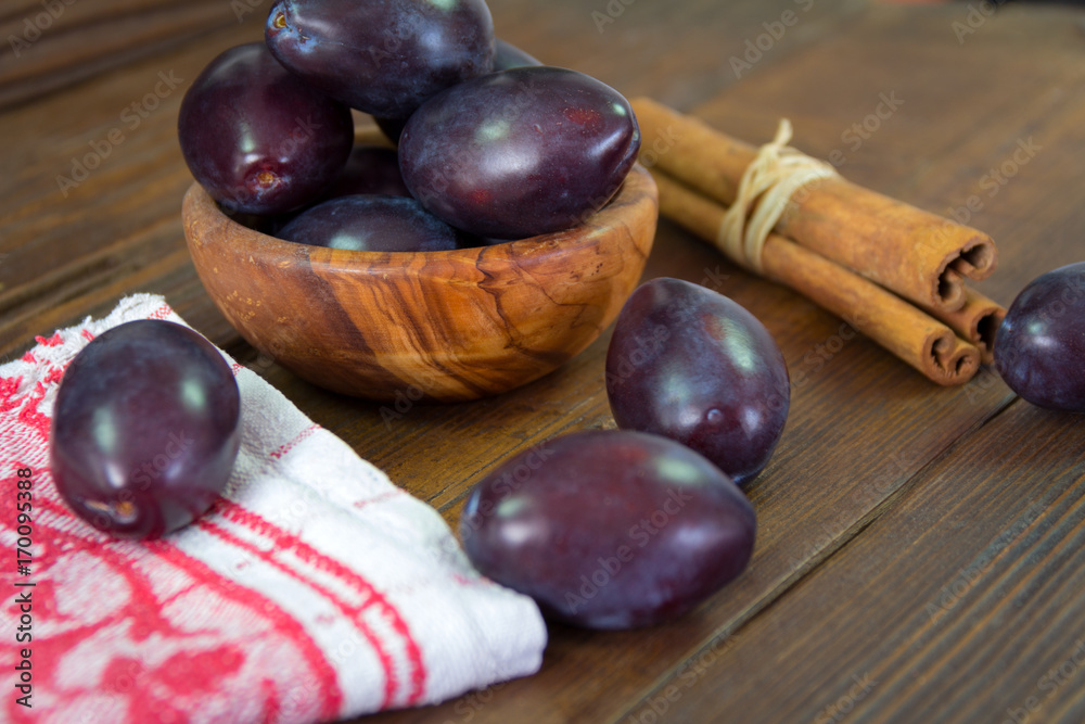 Plums in the bowl and plums sprinkled on the table Plums in the bowl and plums sprinkled on the table