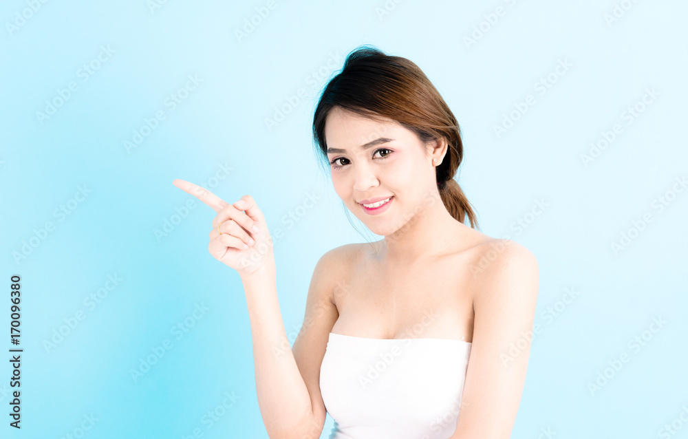 Asian young beautiful confidence woman smiling portrait pointing finger over blue background. Asian young beautiful confidence woman smiling portrait pointing finger over blue background.
