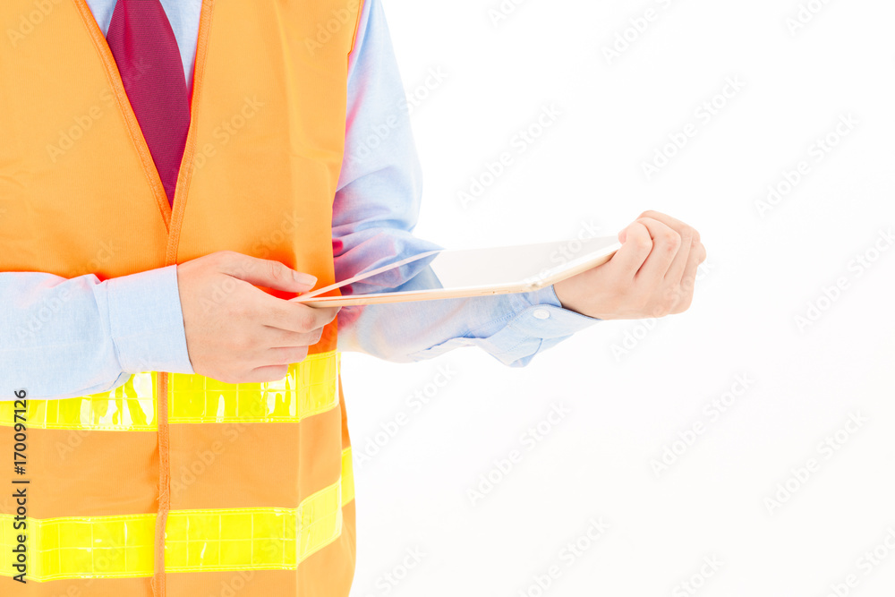 Young confident asian man, orange safety hat, orange safety jacket, safety glass, red tie, blue shirt on white using smart device.