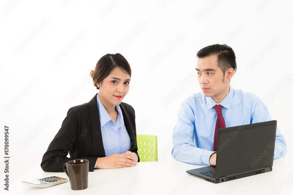 Young attractive confident Asian male business man and woman sitting on desk discussing work over coffee with laptop document on white background Young attractive confident Asian male business man and woman sitting on desk discussing work over coffee with laptop document on white background