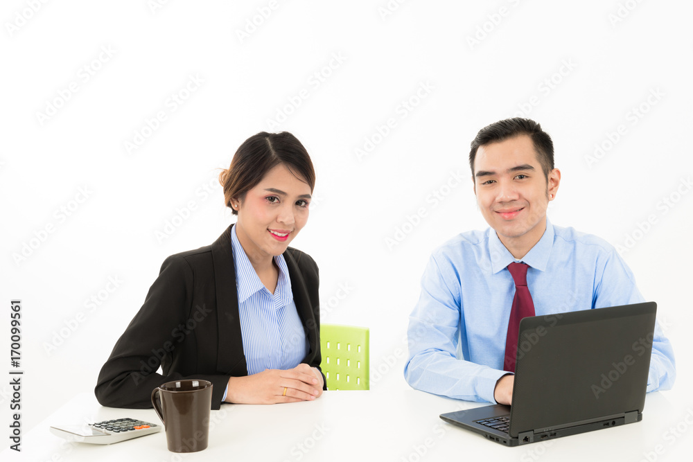 Young attractive confident Asian male business man and woman sitting on desk discussing work over coffee with laptop document on white background Young attractive confident Asian male business man and woman sitting on desk discussing work over coffee with laptop document on white background