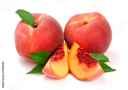 Peaches and slice with a green leaf isolated on white background