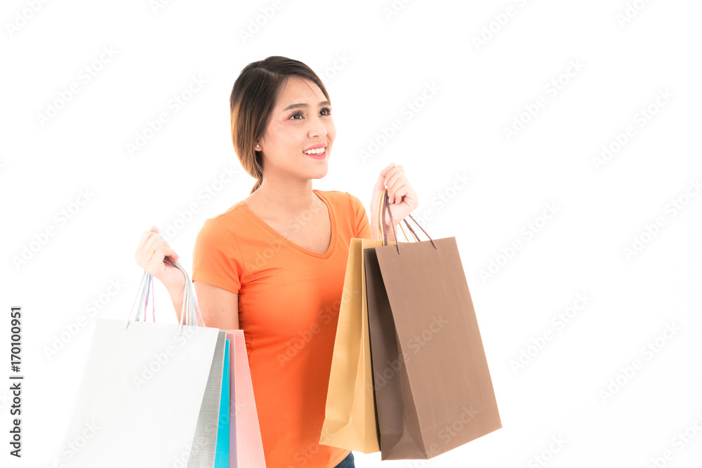 Young confident attractive Asian orange shirt woman with shopping bags standing with portrait on white background. Young confident attractive Asian orange shirt woman with shopping bags standing with portrait on white background.