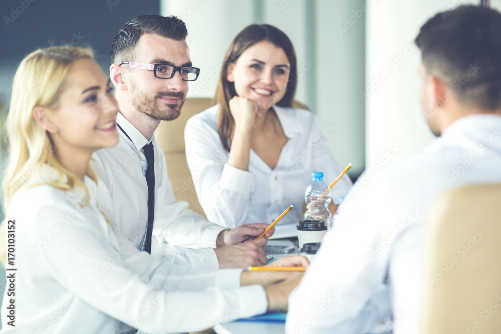 The happy business people sit at the table and talk The happy business people sit at the table and talk