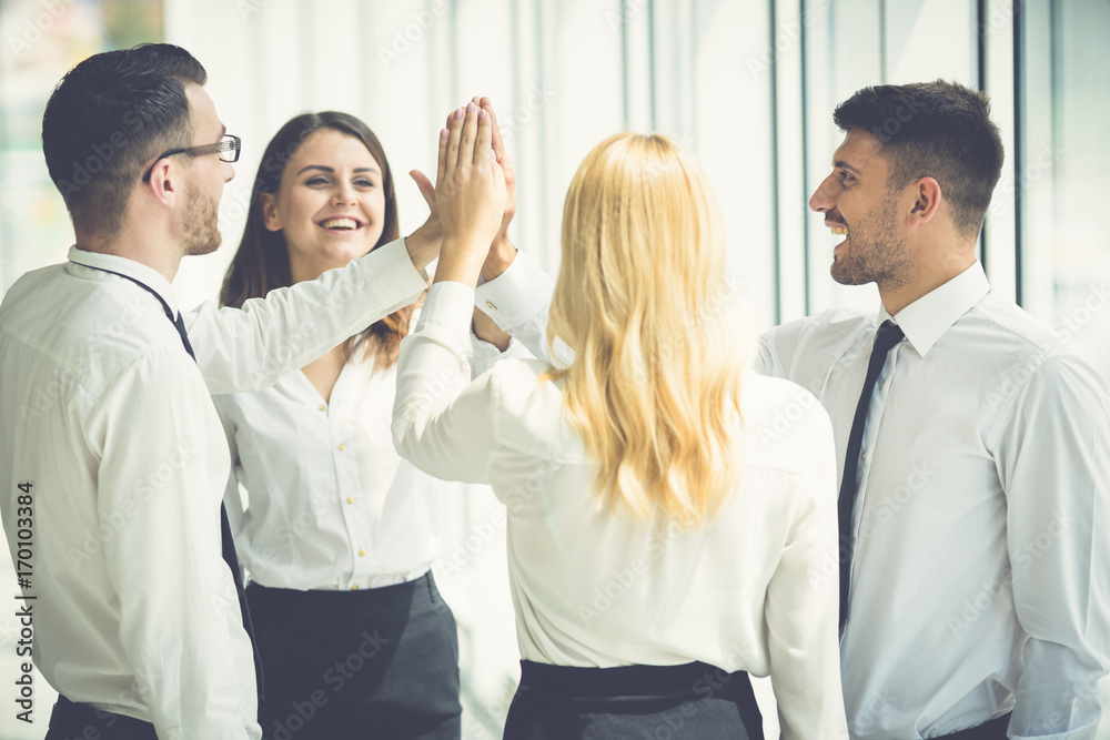 The four business people greeting with a high five The four business people greeting with a high five