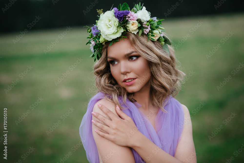 Obraz premium beauty woman portrait with wreath of flowers on head. bride in purple dress Outdoor. soft focus