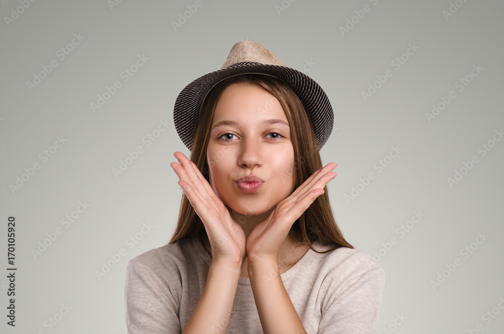 Positive casual woman posing. Emotional girl portrait. Young female with hat. The model is looking at the camera.