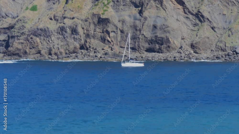 sailing ship sailing under cliffs on the coast of madeira