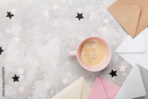 Feminine office workplace with coffee and mail envelopes top view. Flat lay style. Simple breakfast.