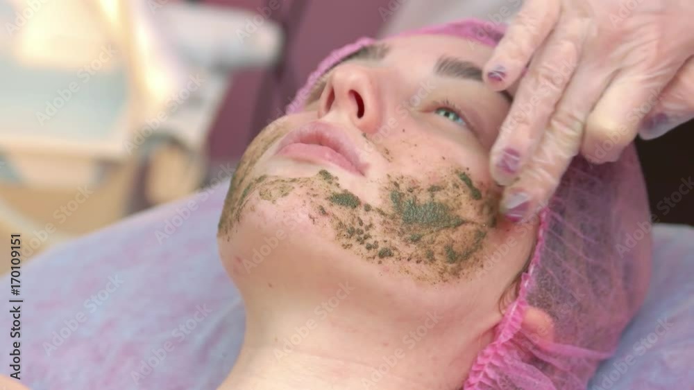 Coral face peeling. Cosmetician is applying facial mask. Organic cosmetics for delicate skin. Coral face peeling. Cosmetician is applying facial mask. Organic cosmetics for delicate skin.