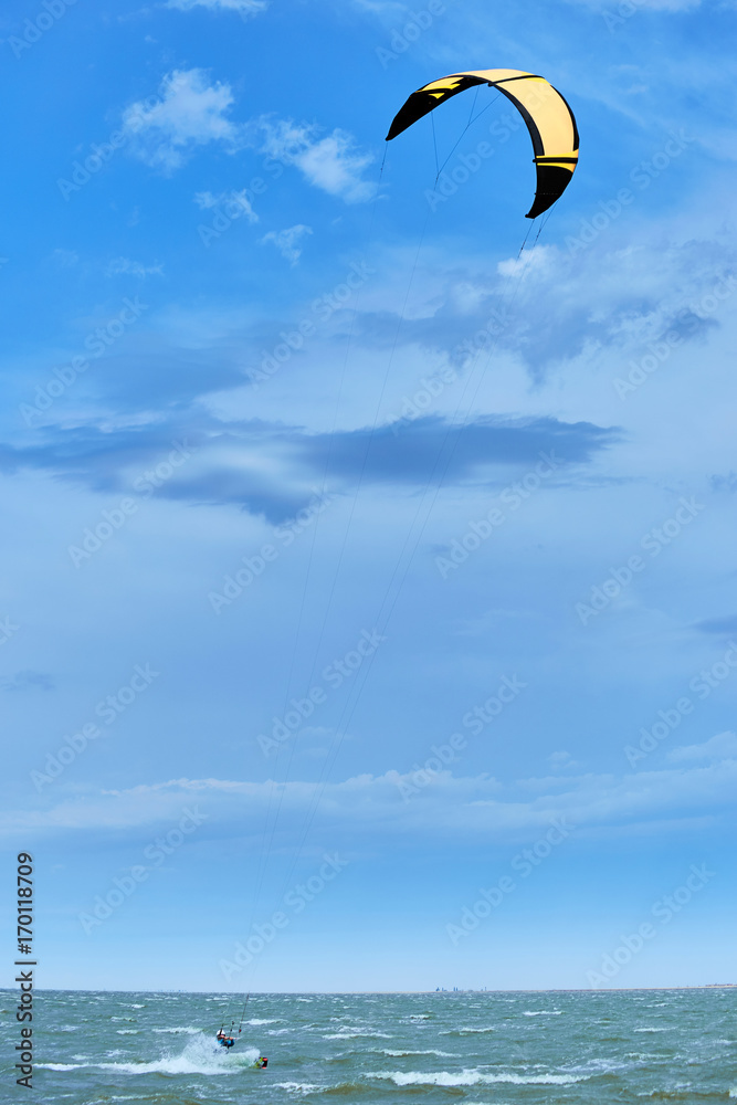 Man riding a kite surfing on the waves in the summer. Man riding a kite surfing on the waves in the summer.