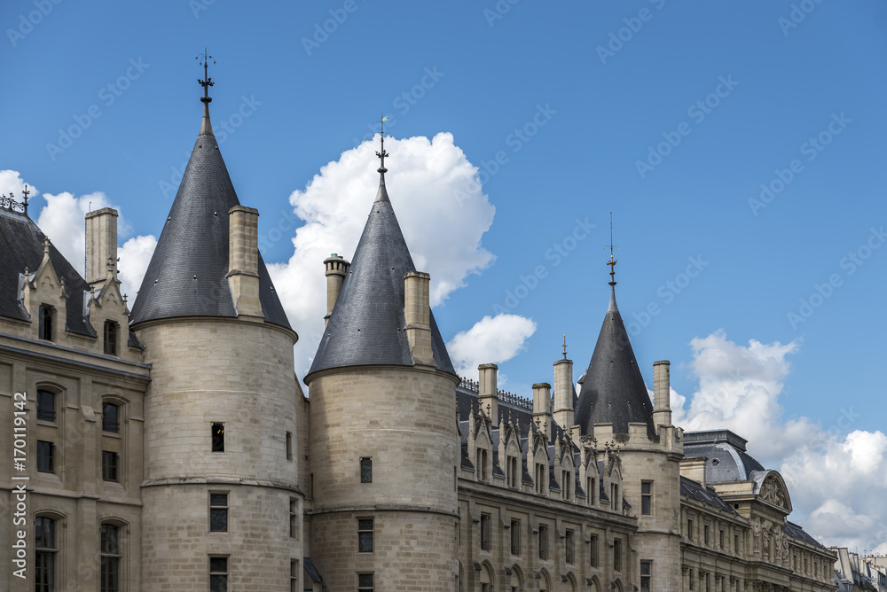 Fototapeta premium Ancient stone building on the banks of the river Seine, Paris. The building has impressive turrets along the exterior wall 