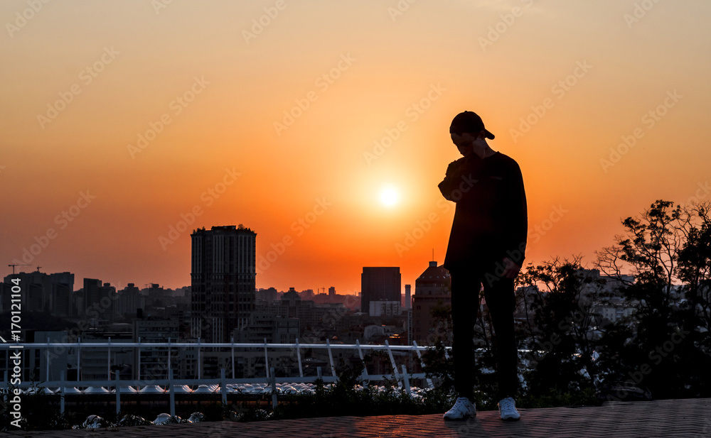 Silhouette of a young man on sunset background Silhouette of a young man on sunset background