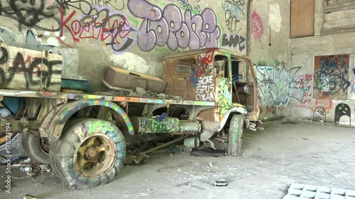 Abandoned lorry in ghost building with murals in Consonno, Italy. Destroyed truck and architecture with graffiti in dead town, demolished vehicle in desolated place