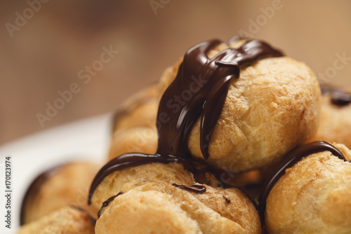 closeup profiteroles with fine dark chocolate on plate photo