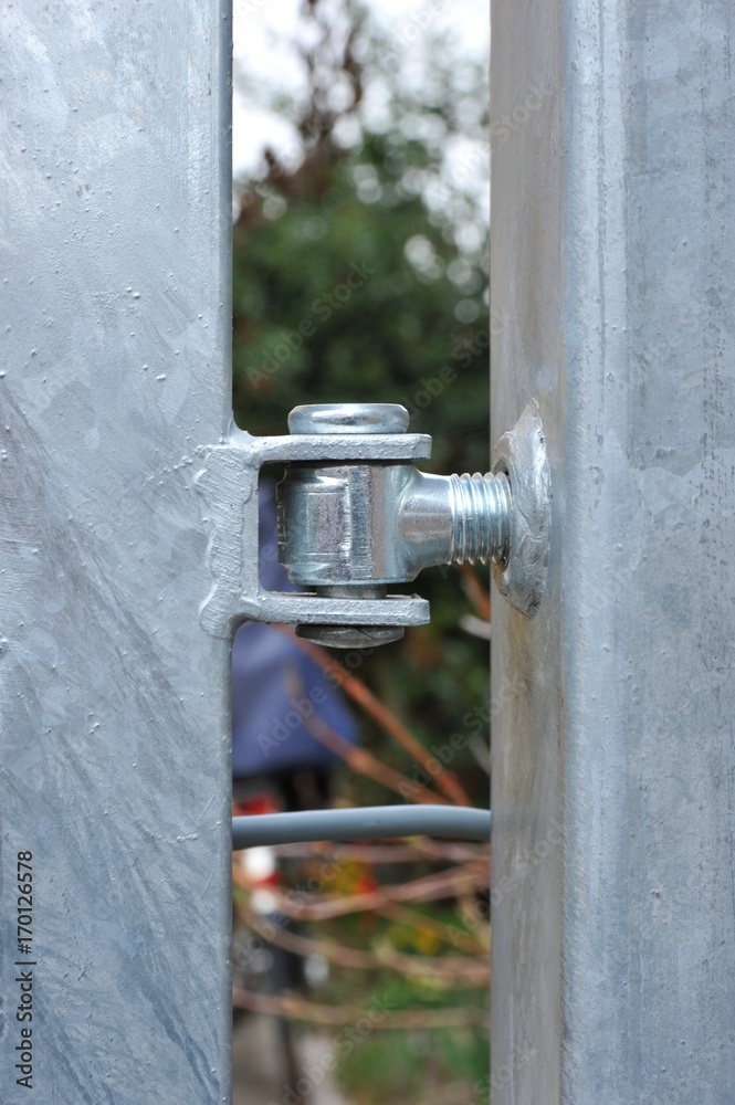 Verschraubung der Säulen eines Metallgitterzauns aus verzinktem Stahl Verschraubung der Säulen eines Metallgitterzauns aus verzinktem Stahl