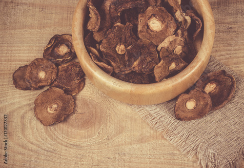Dried forest mushrooms on a wooden table.