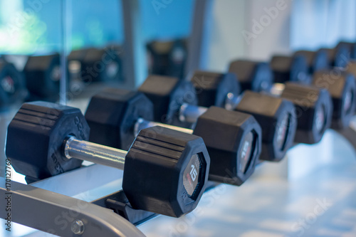 Row of Black dumbbell set. Close up many dumbbells in sport fitness center. Equipment in Sports club.