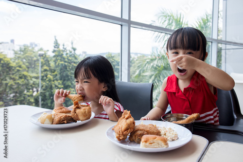 Asian Chinese little girls eating fried chicken