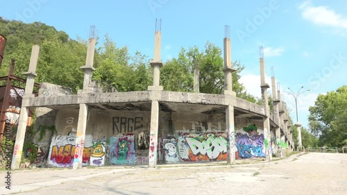 Abandoned silo and construction site with murals in Consonno, Italy. Rusted concrete tank and unfinished building with graffiti in dead town, desolate and scary place